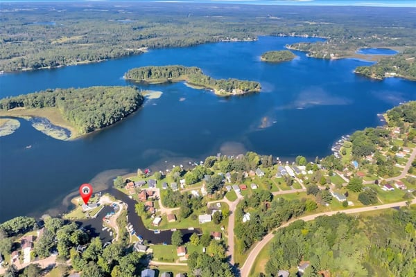 Michigan lakefront shoreline with waterfront homes and boat docks on a clear summer day