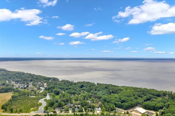 Michigan lakefront shoreline with waterfront homes and boat docks on a clear summer day